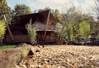 Tienda glamping Hacienda en Resort de Parel, Países Bajos, con terraza de madera y entorno natural.