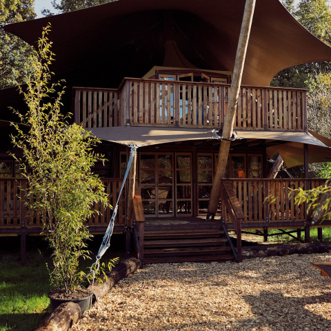 Tienda glamping safari Hacienda con terrazas de madera en Resort de Parel, Países Bajos, rodeada de naturaleza.