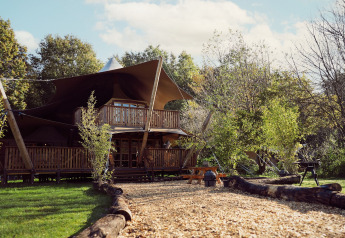 Luxuriöses Safari-Zelt Hacienda im Resort de Parel, Niederlande, umgeben von Natur und Holzmöbeln.