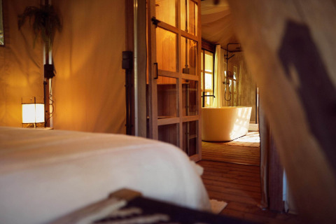 Intérieur de la tente safari Hacienda au Resort de Parel, Pays-Bas, avec baignoire et ambiance chaleureuse.