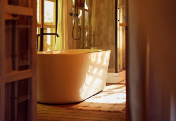 Luxe bad in een glamping tent op Resort de Parel, Nederland, met zacht zonlicht door het raam.