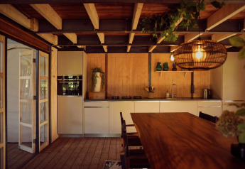 Modernes Safari-Zeltküche und Essbereich mit Holzdecken bei Resort de Parel, Niederlande, gemütlich beleuchtet.