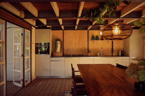 Modernes Safari-Zeltküche und Essbereich mit Holzdecken bei Resort de Parel, Niederlande, gemütlich beleuchtet.