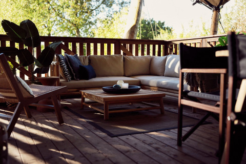 Hyggelig loungeområde på en træterrasse ved glamping-telt Hacienda, Resort de Parel, Holland.