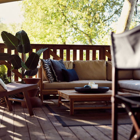 Coin salon chaleureux dans une tente de glamping safari au Resort de Parel, Pays-Bas, avec mobilier bois.