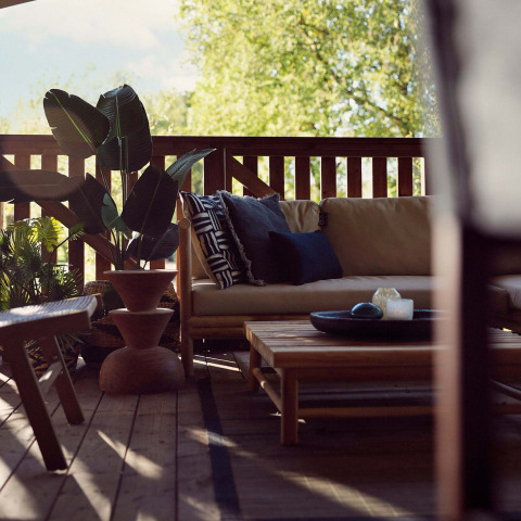 Gemütliche Terrasse im Glampingzelt Hacienda im Resort de Parel, Niederlande, mit Sofa und Pflanzen.