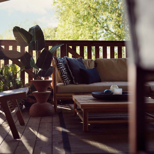 Terraza luminosa en la tienda Hacienda de Resort de Parel, Países Bajos, con sofá y plantas decorativas.