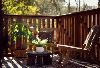 Zona de estar exterior en la tienda Glamping Hacienda en Resort de Parel, Países Bajos, con sillas y plantas.