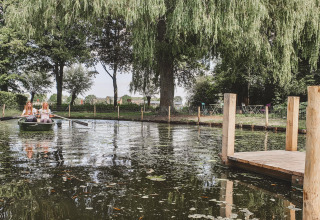 Twee vrouwen in een roeiboot op een vijver aan een steiger bij Feather Down Hoeve Brugge, West-Vlaanderen.