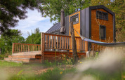 Tiny House en Holiday Park Sallandshoeve, Países Bajos, con terraza de madera y hamaca en plena naturaleza.
