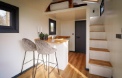 Intérieur moderne d'une tiny house avec cuisine, coin repas et mezzanine au Holiday Park Sallandshoeve, Pays-Bas.