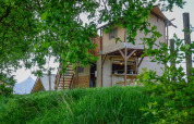 Tienda tipo safari 'Treehouse tent' en Holiday Park Mölke, Países Bajos, rodeada de árboles y césped.