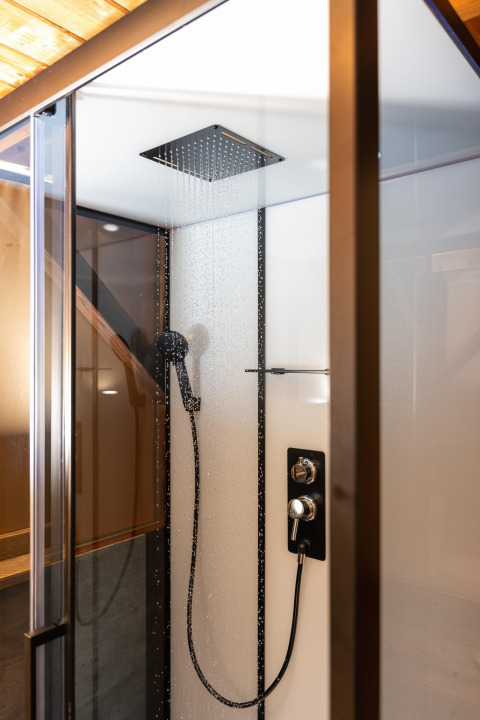 Moderne douche met regendouchekop en handdouche in de Treehouse tent te Holiday Park Mölke, Nederland.