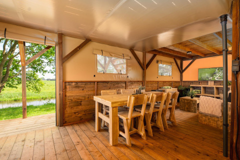 Interieur van de Treehouse safaritent bij Holiday Park Mölke in Nederland met houten meubels.