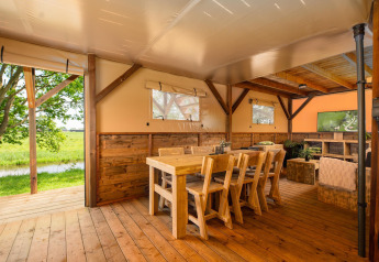 Indretning af en safari-telt Treehouse ved Holiday Park Mölke i Holland med træmøbler og udsigt.