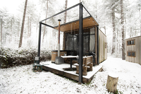 La pequeña casa Sweet Cabin con bañera de hidromasaje, rodeada de nieve en el bosque de Limburgo, Bélgica.
