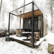 La pequeña casa Sweet Cabin con bañera de hidromasaje, rodeada de nieve en el bosque de Limburgo, Bélgica.
