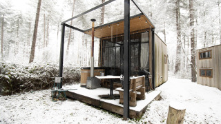 En lille hytte kaldet Sweet Cabin med udendørs badekar og sne omkring, beliggende i en skov i Limburg, Belgien.
