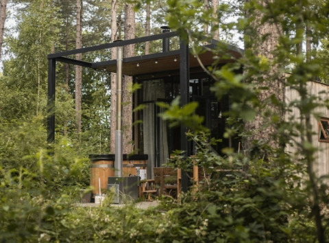 Sweet Cabin tiny house met buiten hot tub, omgeven door bos en natuur, ideaal voor ontspanning.