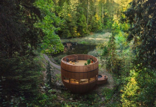 Rond tiny house The Nutshell met hot tub en sauna in het bos van Recreatiepark Den Blanken, Nederland.