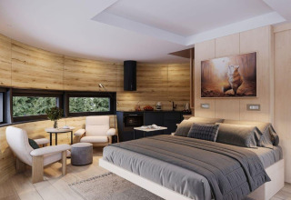 Moderne tiny house slaapkamer met houtpanelen, dubbel bed, zithoek en grote ramen in natuur.