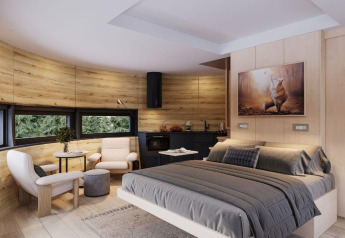 Moderne tiny house-soveværelse med træpaneler, dobbeltseng, hyggeligt siddeområde og store vinduer.