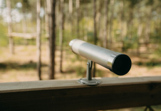 Telescopio en la terraza de una casa del árbol en Treetop de Cosy Cabins en el bosque de Limburg, Bélgica.