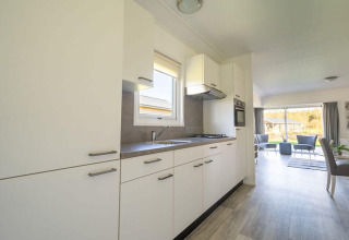 Moderne keuken en woonkamer met grote ramen in een Velthorst lodge bij EuroParcs Veluwemeer, Nederland.