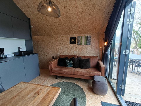 Vue intérieure du lodge Solo Retreat à EuroParcs Veluwemeer avec décoration moderne et accès à la terrasse.