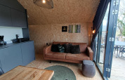 Vista interior de la cabaña Solo Retreat en EuroParcs Veluwemeer, con decoración moderna y acceso a la terraza.