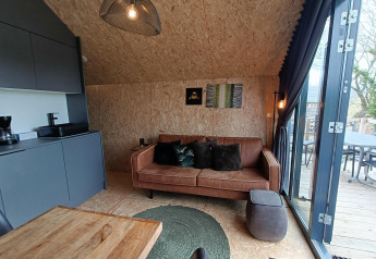 Vista interna del lodge Solo Retreat a EuroParcs Veluwemeer con arredo moderno e accesso alla terrazza.