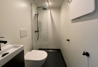 Bagno moderno e minimalista con doccia, WC e lavandino al Solo Retreat, EuroParcs Veluwemeer nei Paesi Bassi.