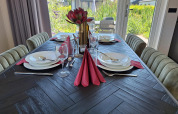 Mesa de comedor elegantemente puesta con servilletas rojas y vista al jardín en Just Nature Lodge, De Rijp, Países Bajos.