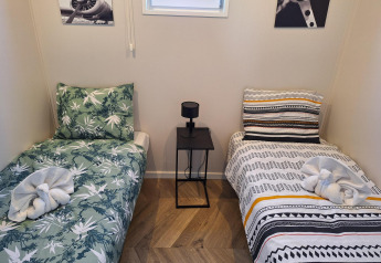 Zweibettzimmer mit dekorativen Handtuch-Schwänen, stilvoller Bettwäsche und modernem Interieur im Just Nature.