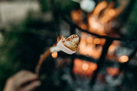 Gerösteter, herzförmiger Marshmallow am Stock über Lagerfeuer im Feather Down TaarTenTuin, Südholland.