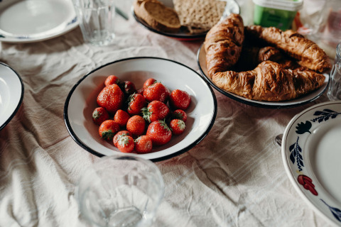 Frühstückstisch mit Erdbeeren, Croissants und Brot bei Feather Down TaarTenTuin, Südholland, Niederlande.