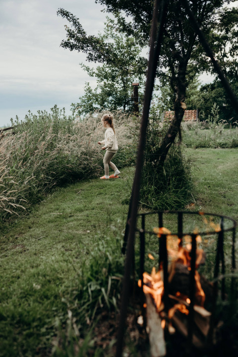 A child walks on the grass near a campfire at Feather Down TaarTenTuin holiday park in South-Holland, Netherlands.