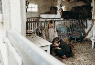 Deux enfants jouent ensemble dans une grange au Feather Down TaarTenTuin, parc de vacances en Hollande-Méridionale.