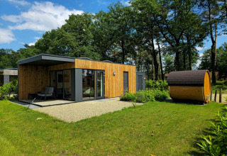 Moderne feriebolig med træfacade og udendørs sauna i grønne omgivelser på Hofparken Wiltershaar, Holland.