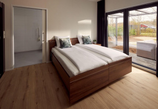 Wheelchair-friendly bedroom at Holiday Villa Amalia 2 with double bed and view of the outdoor terrace.