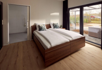 Wheelchair-friendly bedroom at Holiday Villa Amalia 2 with double bed and view of the outdoor terrace.