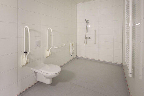 Baño accesible con barras de apoyo, inodoro suspendido y ducha abierta en Holiday villa Amalia 2.