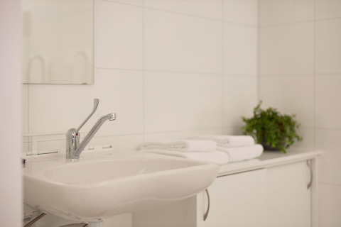 Handicapvenligt badeværelse i Holiday villa Amalia 2, Hofparken Wiltershaar, Holland, med vask og håndklæder.