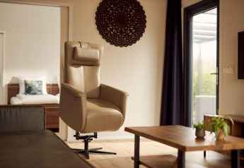 Woonkamer met rolstoelvriendelijke fauteuil in vakantiehuis Amalia 2 bij Hofparken Wiltershaar, Nederland.