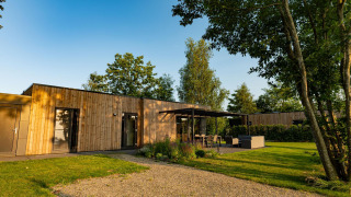 Ferienvilla Amalia 6 im Hofparken Wiltershaar, mit moderner Holzfassade und Gartenbereich in den Niederlanden.