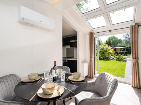 Eethoek in Cozy Chalet te Veluwepark de Bosgraaf, Nederland, met modern interieur en zicht op de tuin.