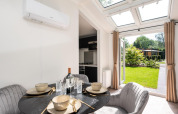 Spisestue i Cozy Chalet ved Veluwepark de Bosgraaf, Holland, med moderne indretning og haveudsigt.