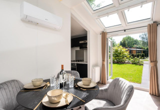 Eethoek in Cozy Chalet te Veluwepark de Bosgraaf, Nederland, met modern interieur en zicht op de tuin.