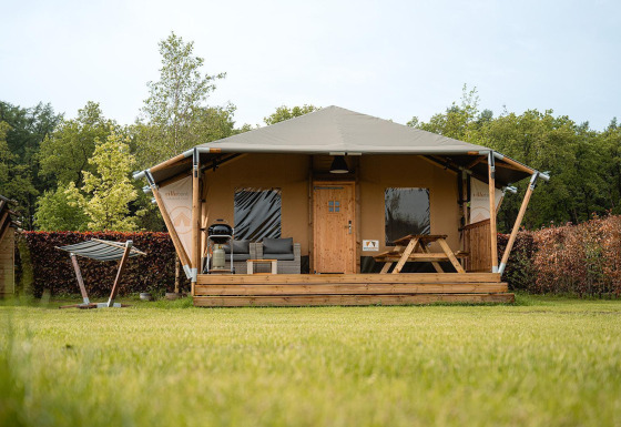 Safari-Zelt Villatent Cottage auf Camping 't Geuldal in den Niederlanden, mit Veranda und grüner Wiese.