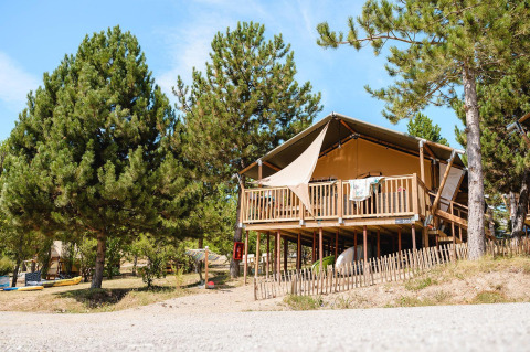 Villatent Nomad lodge bij Camping La Presqu’île in Frankrijk, safaritent op palen in groene dennenbossen.